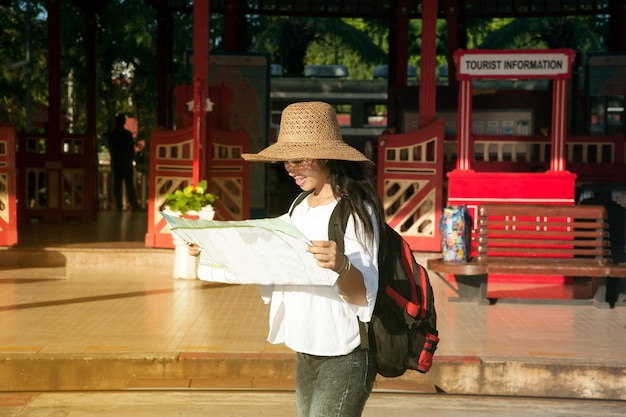 Photo woman looking at map while standing at railroad station