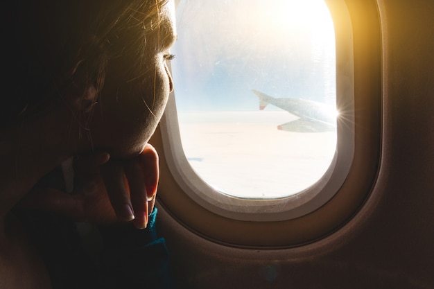 Photo woman looking out through airplane window