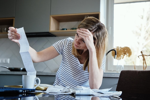 Woman looking at paper bill and counting expenses planning budget and home finance management