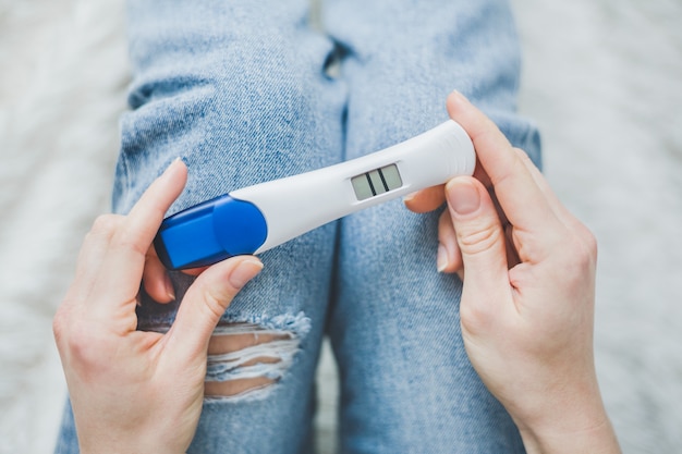 Woman looking on positive pregancy test