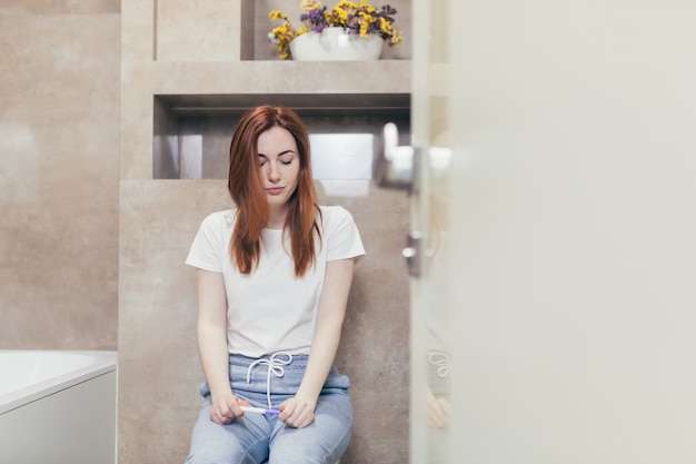 woman looking at a quick positive or negative result pregnancy test