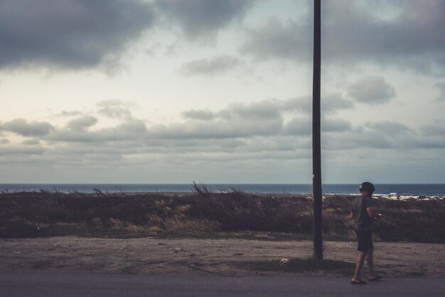 Woman looking at sea against sky