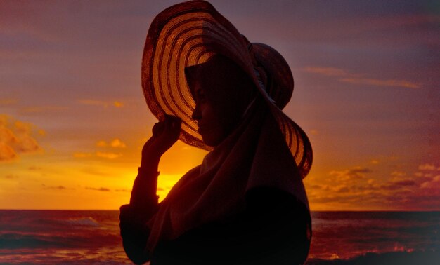 Photo woman looking at sea during sunset