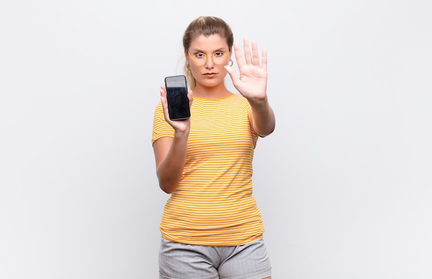 Woman looking serious making stop gesture