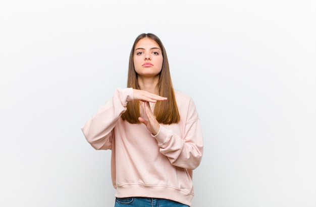 woman looking serious, stern, angry and displeased, making time out sign