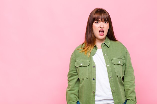 Woman looking shocked, angry, annoyed or disappointed, open mouthed and furious