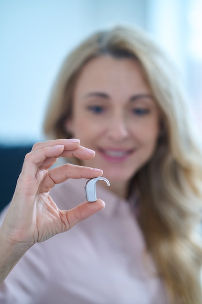 Woman looking at small hearing aid