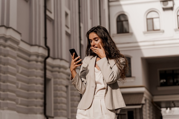 Woman looking at smartphone in shock