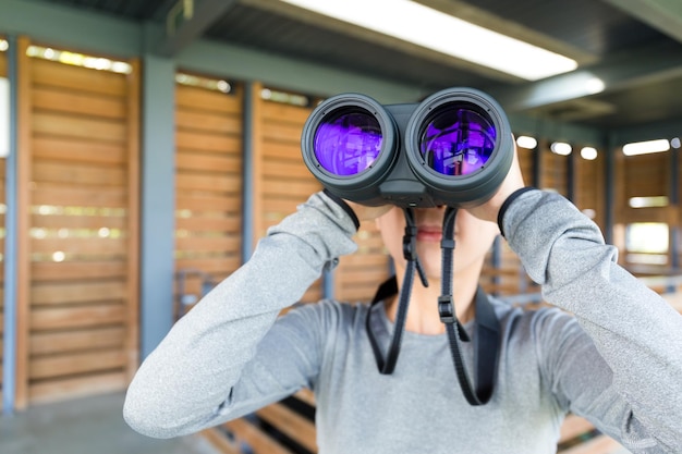 Foto donna che guarda con il binocolo