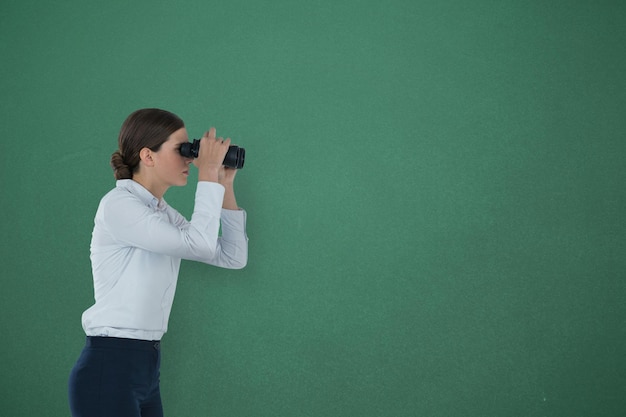 Woman looking through binoculars against green background