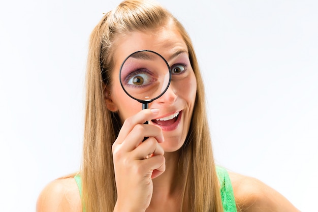 Woman looking through magnifying glass or loupe