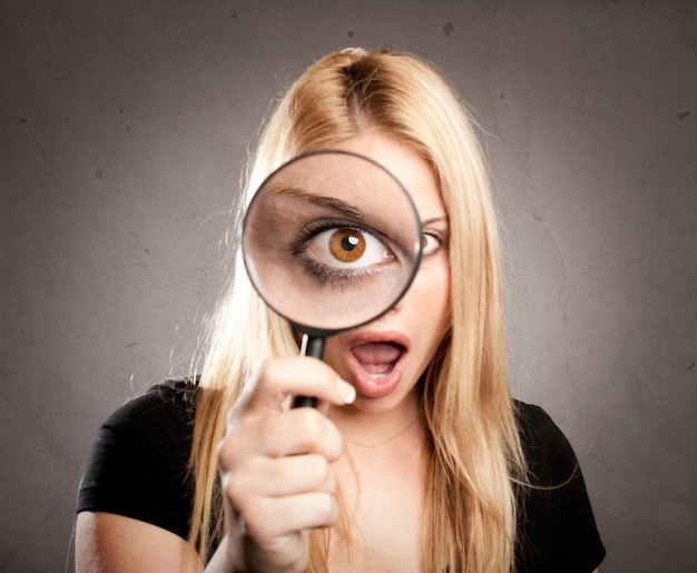 Woman looking through magnifying glass