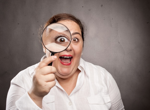 woman looking at through magnifying glass