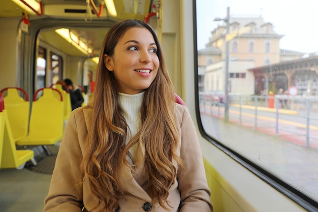 Woman looking through the window sitting on tram