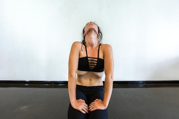 Woman looking up while meditating against wall