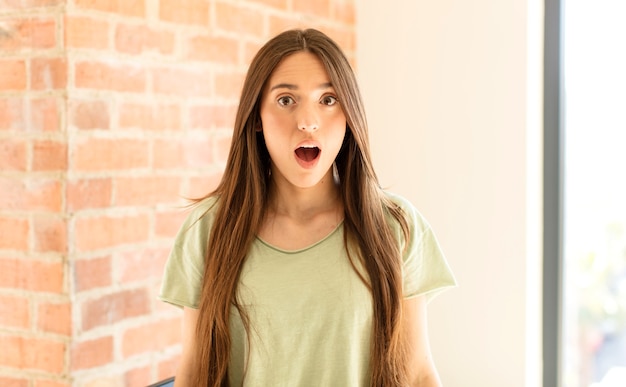 Photo woman  looking very shocked or surprised, staring with open mouth saying wow