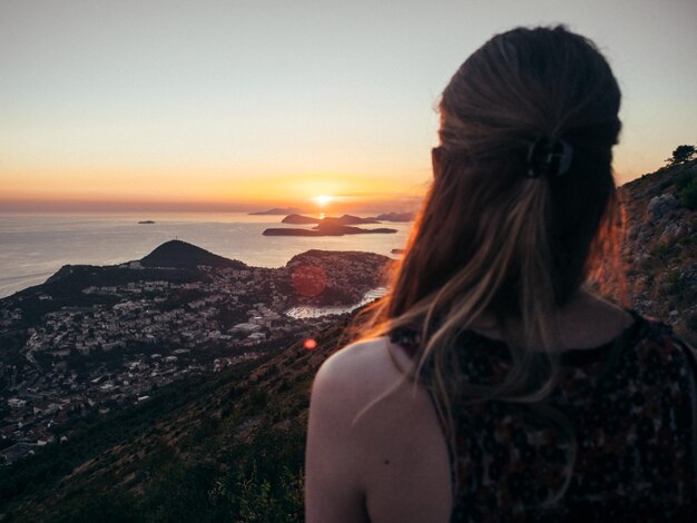 Foto donna che guarda la vista contro il cielo durante il tramonto