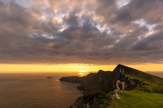 Achill Island Ireland의 Croaghaun Cliffs를 바라보는 여성