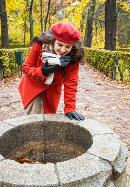 Foto donna che guarda un pozzo d'acqua nel parco