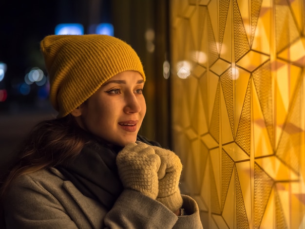 Woman looks on display on night street