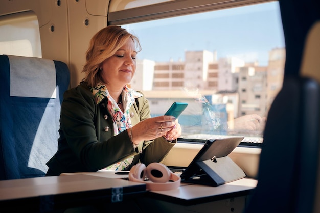 Woman looks at her mobile phone while she is traveling by train