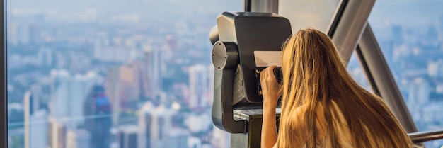 Woman looks at kuala lumpur cityscape panoramic view of kuala lumpur city skyline evening at sunset