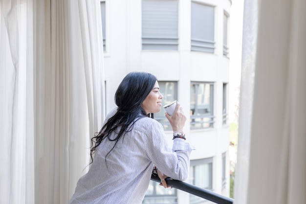 Photo woman looks out a hotel window