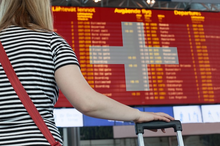 Photo 女性は空港のスコアボードを見て旅行や移住のために国を選択します