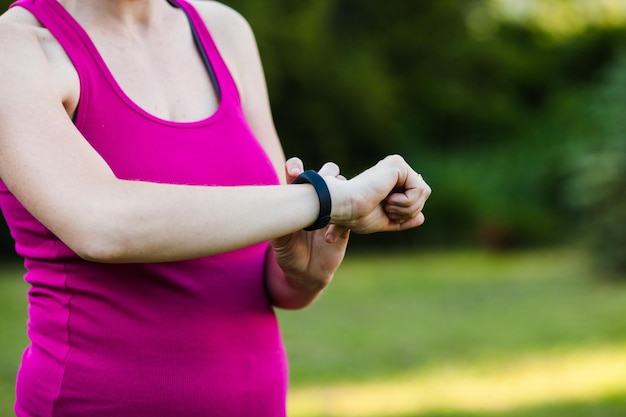 Woman looks at the sport clock during the morning run