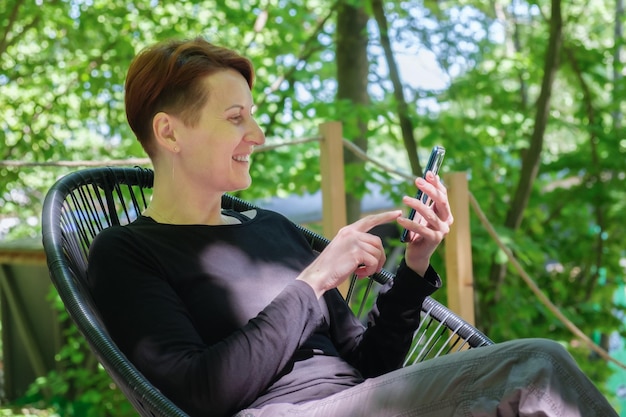 Woman looks through information on a smartphone and smiles