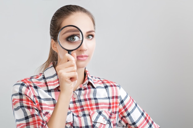 Woman looks through a magnifying glass