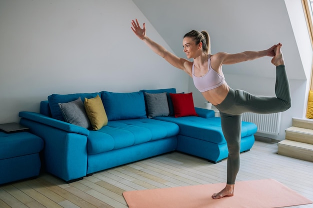 Woman in Lord of the dance yoga pose training at home