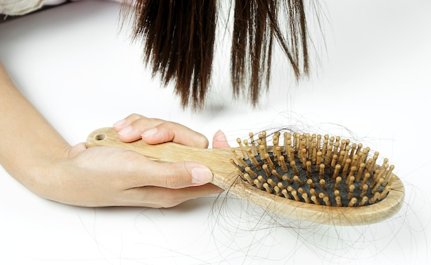 Woman losing hair on hairbrush in hand Hair loss hair fall everyday serious problem