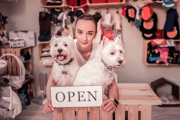 ペットを愛する女性。ペットのための店を開いている間素晴らしい感じのペットを愛する暗い目の女性