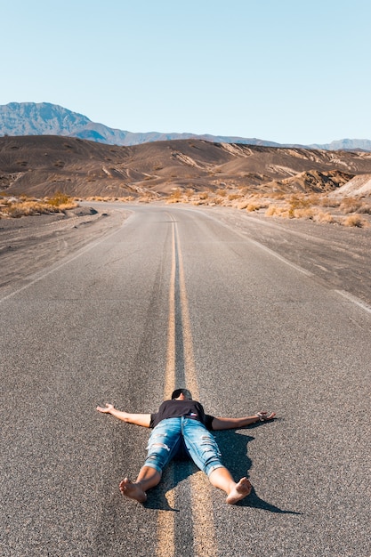 데스 밸리의 빈 도로에 맨발로 누워있는 여자