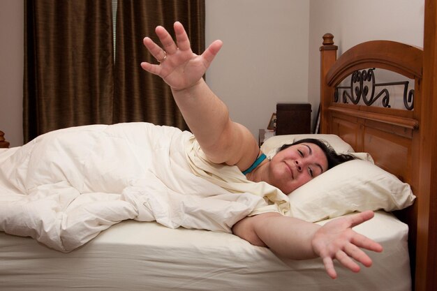 Foto donna sdraiata a letto a casa