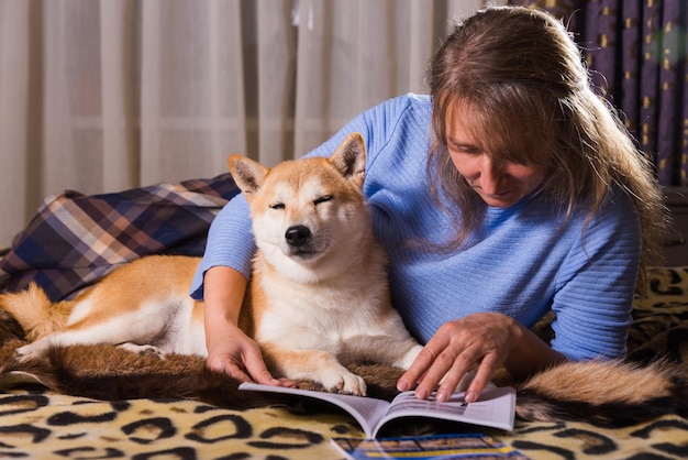 ベッドに横になって本を読んでいる女性