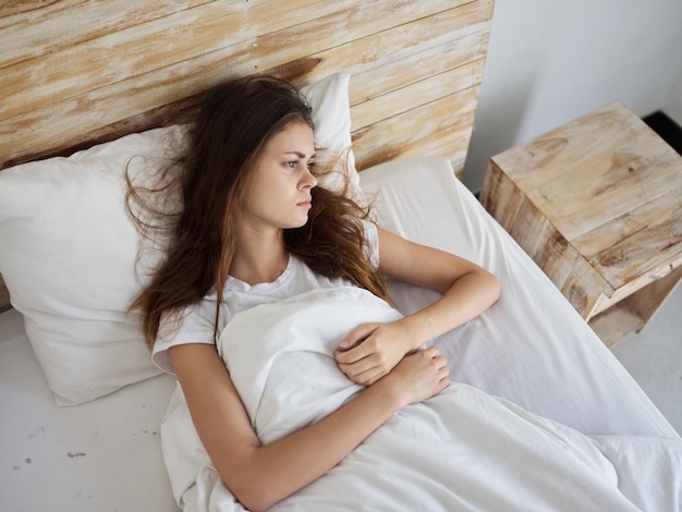 Woman lying in bed sad facial expression discontent