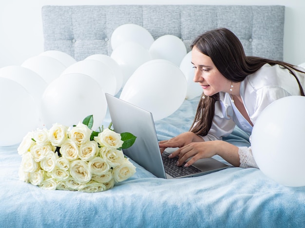 Woman lying on bed with decorations with balloons for Birthday party