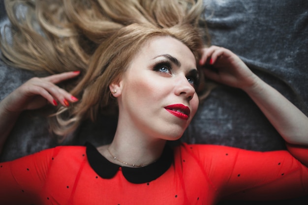 Woman lying on a bed with painted lips