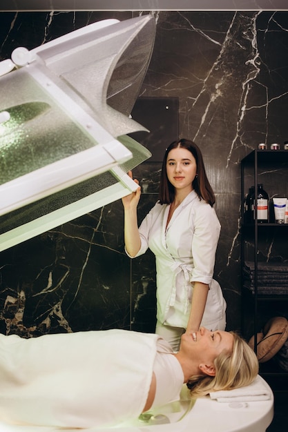 Woman lying in the capsule at the spa salon