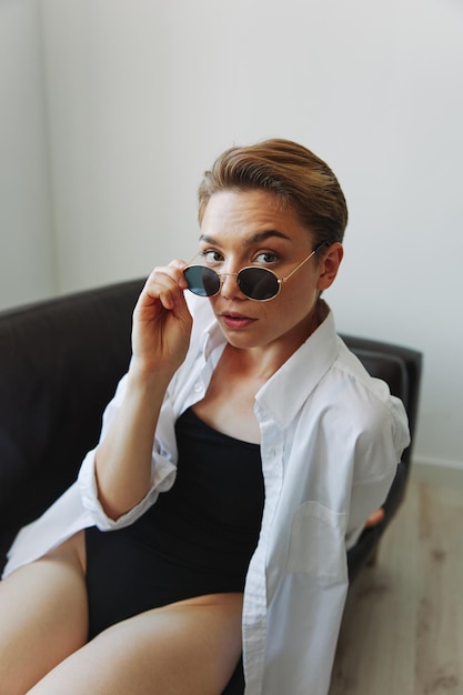 A woman lying on the couch with her glasses on and wriggling