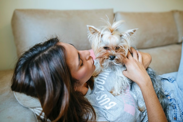 Woman lying on couch with her Yorkshire Terrier
