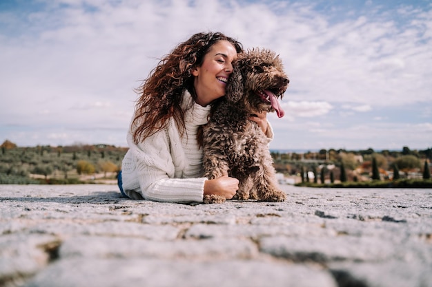 woman lying down on floor with dog outdoors