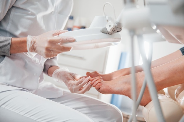 Woman lying down and have operation on her feet by professional
clinic worker