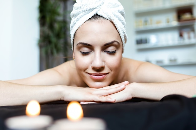 Woman lying down with her eyes closed and a towel in her hair