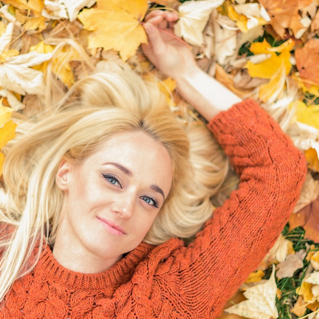 Woman lying down on yellow leaves