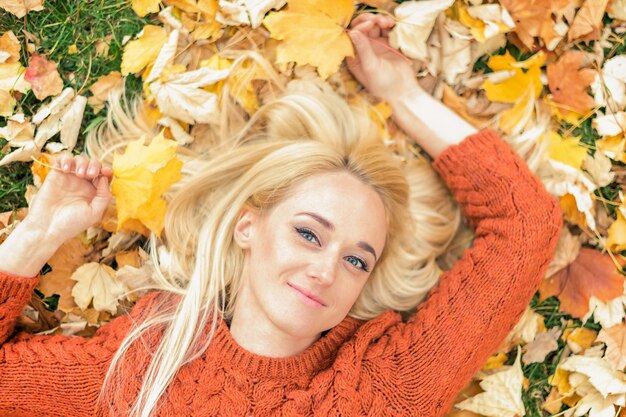 Женщина, лежа на желтых листьях