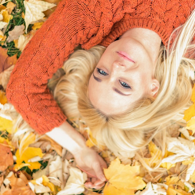 Woman lying down on yellow leaves