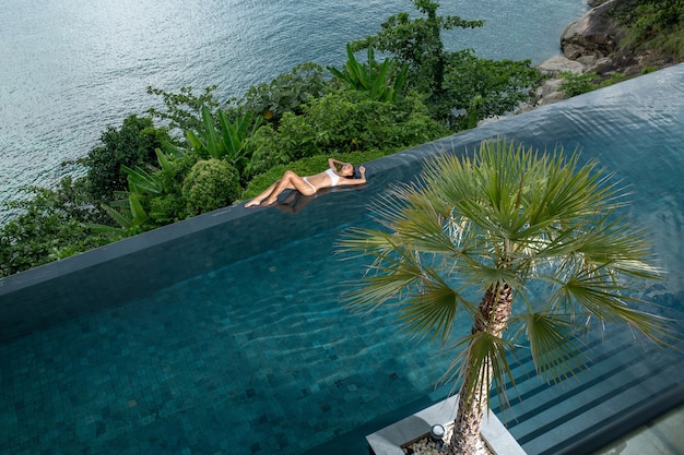 Woman lying on the edge of an infinity pool